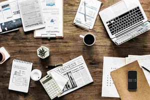 Scatter desk of writer working on newsletter writing topics for company with copy cup laptop
