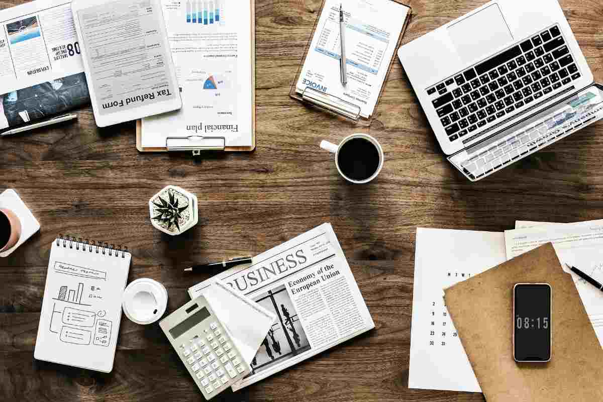Desk with laptop and notes for planning employee newsletter topics